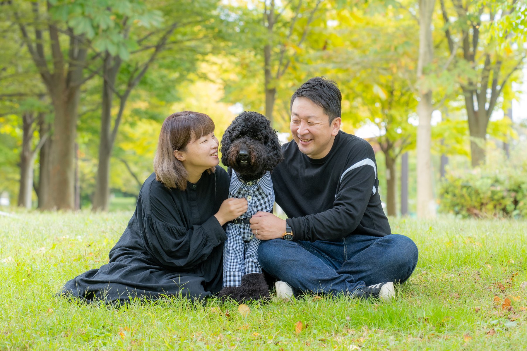 公園で愛犬を囲む家族